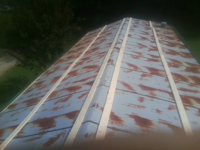 Rusted metal roof panels with new wood purlins before replacement — Storm Damage Roof Repair in Bessemer City by Roofing Brothers