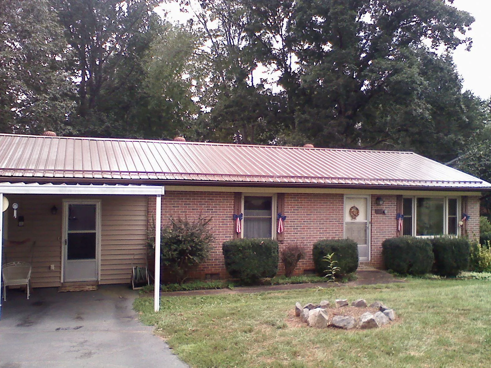 Bronze metal roof and carport on a brick ranch home — Roof Repair work by our crew in Bessemer City
